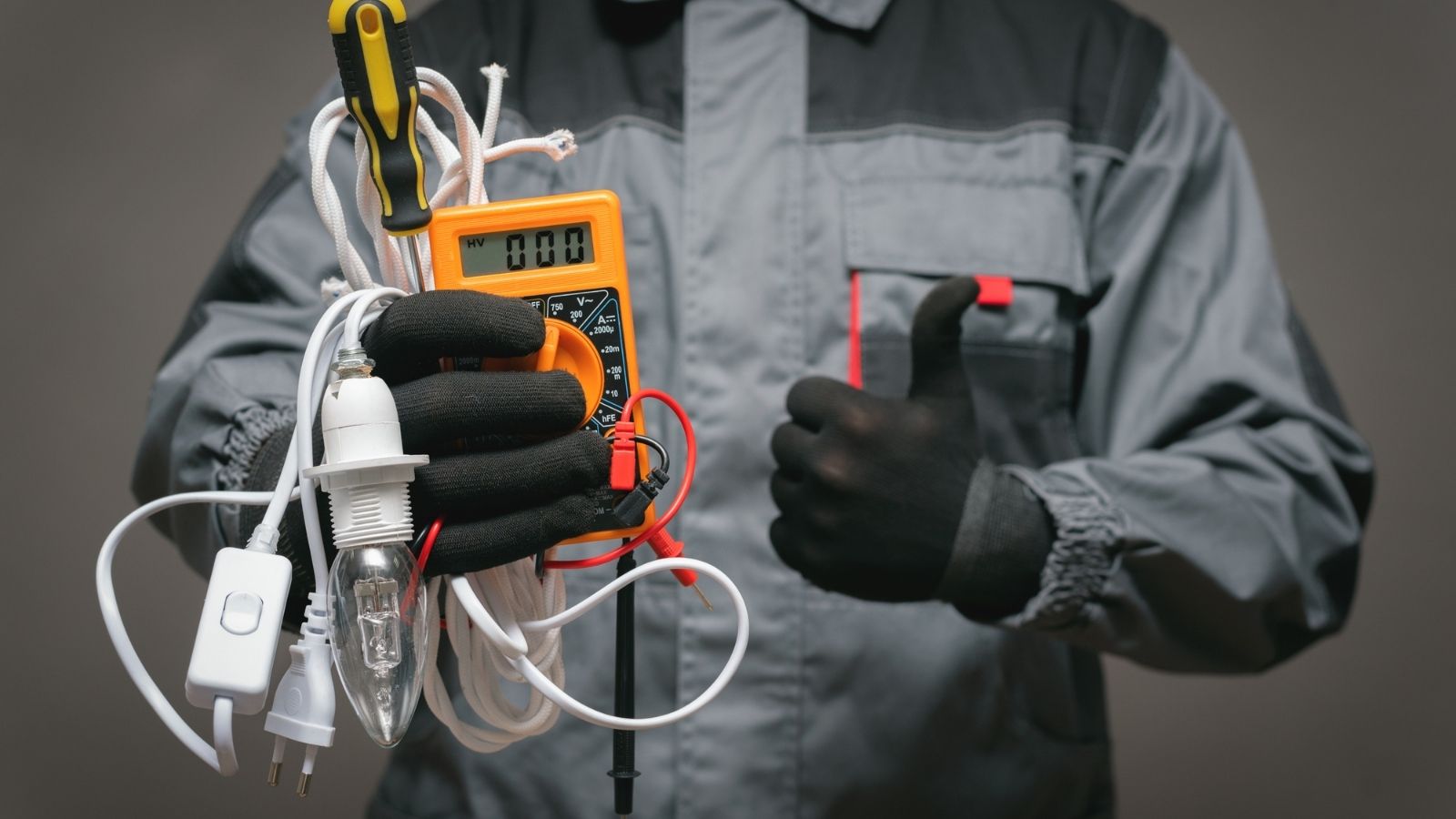Electrician holding tools and giving thumbs up Electrician holding tools and giving thumbs up
