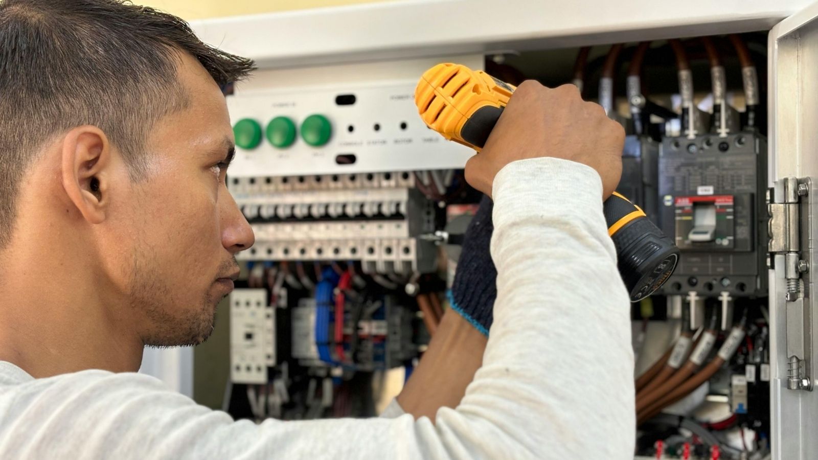 Electrician repairing electrical panel with tools Electrician repairing electrical panel with tools