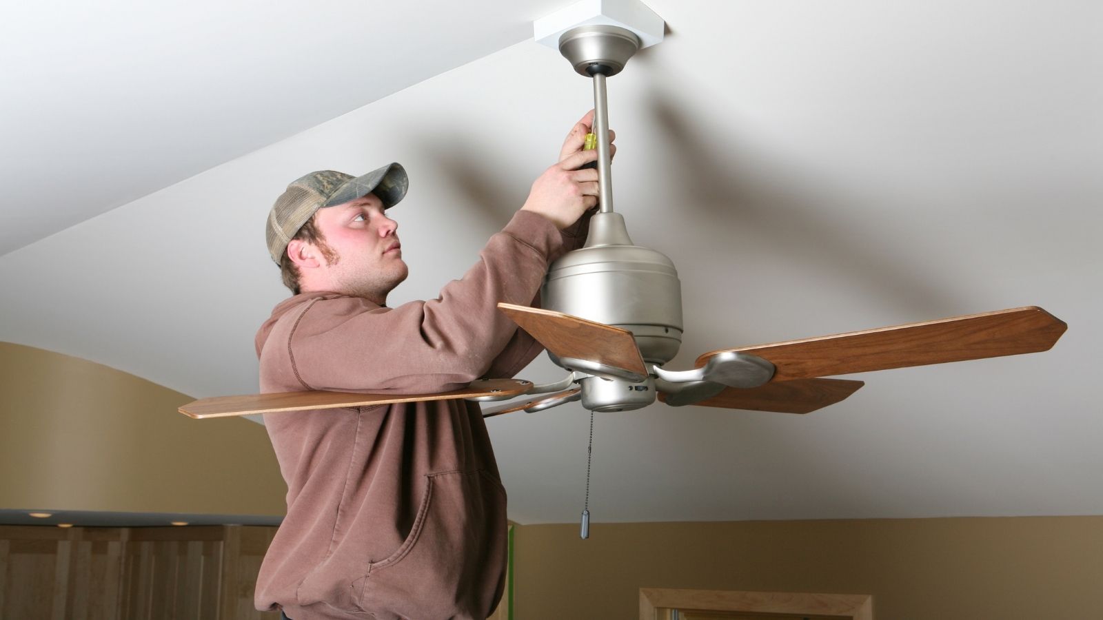 Electrician installing ceiling fan Electrician installing ceiling fan