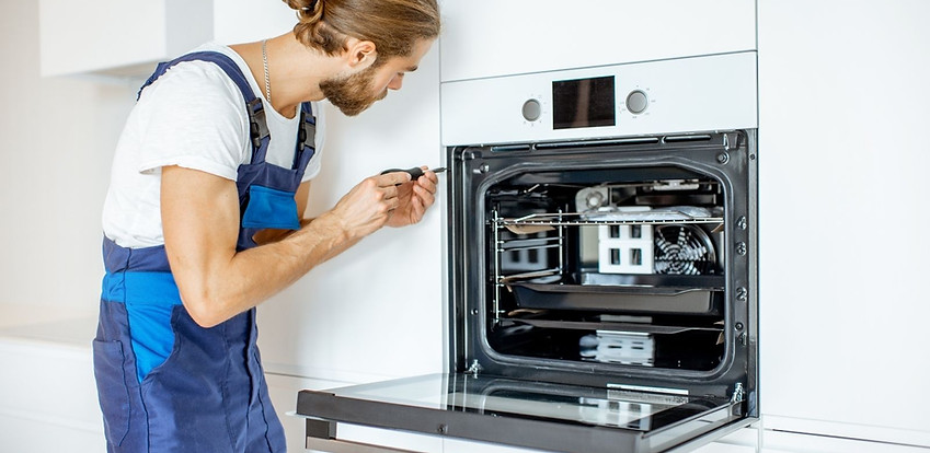 Technician completing appliance electrical connection work Technician completing appliance electrical connection work